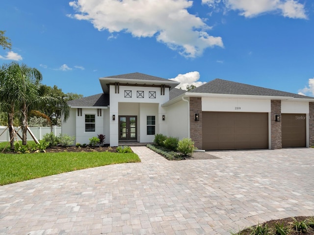 prairie-style home featuring a garage and french doors