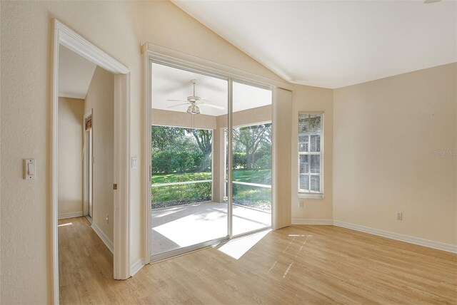 doorway to outside with vaulted ceiling, light wood-type flooring, a ceiling fan, and baseboards