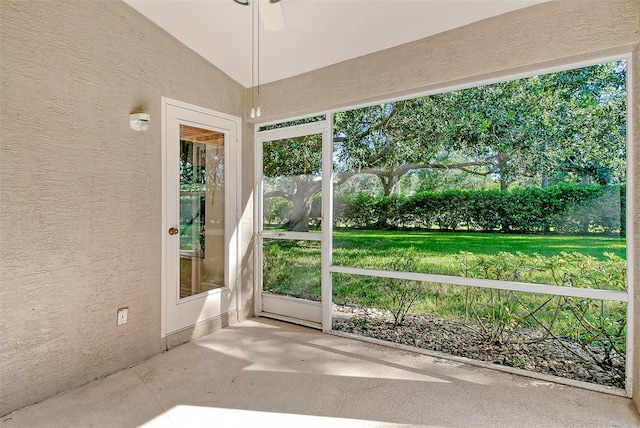 unfurnished sunroom featuring ceiling fan and vaulted ceiling