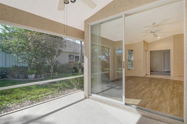 unfurnished sunroom with lofted ceiling and a ceiling fan