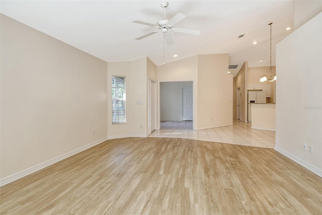 unfurnished room with ceiling fan with notable chandelier, visible vents, baseboards, vaulted ceiling, and light wood-style floors