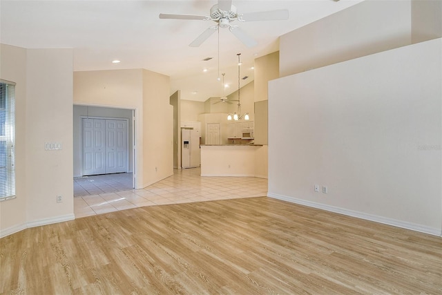 unfurnished living room featuring ceiling fan, high vaulted ceiling, light wood-type flooring, and baseboards