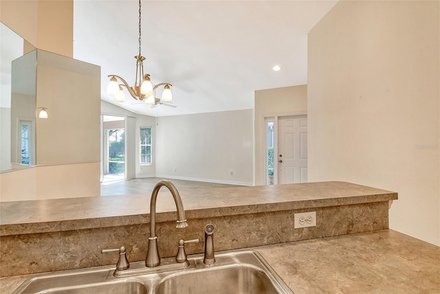 kitchen with lofted ceiling, open floor plan, hanging light fixtures, a chandelier, and a sink