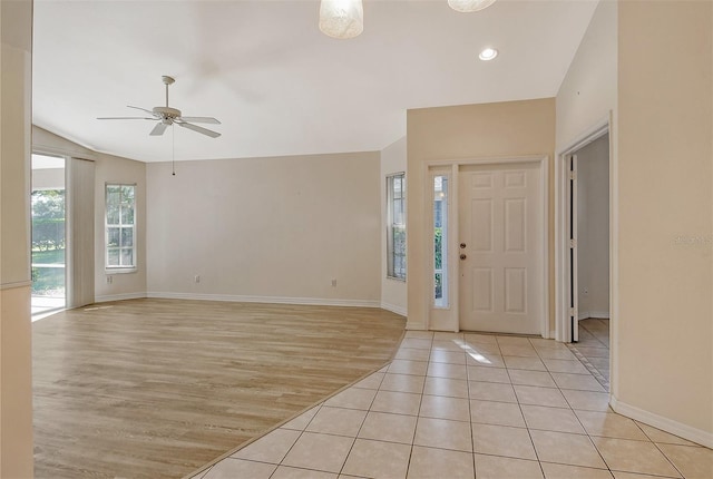 foyer with light wood-style floors, lofted ceiling, ceiling fan, and baseboards