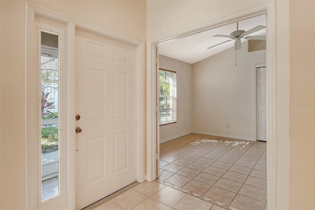 foyer featuring light tile patterned floors, ceiling fan, lofted ceiling, and baseboards