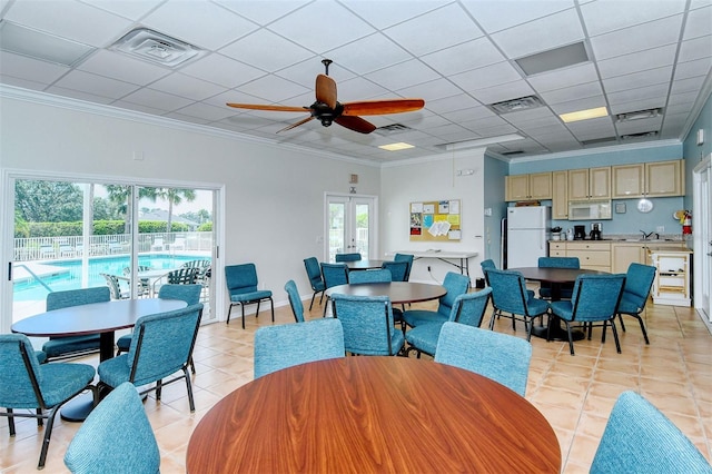 dining space with a wealth of natural light, visible vents, and crown molding