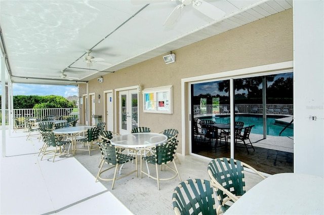 view of patio with a fenced in pool, french doors, outdoor dining area, a ceiling fan, and fence