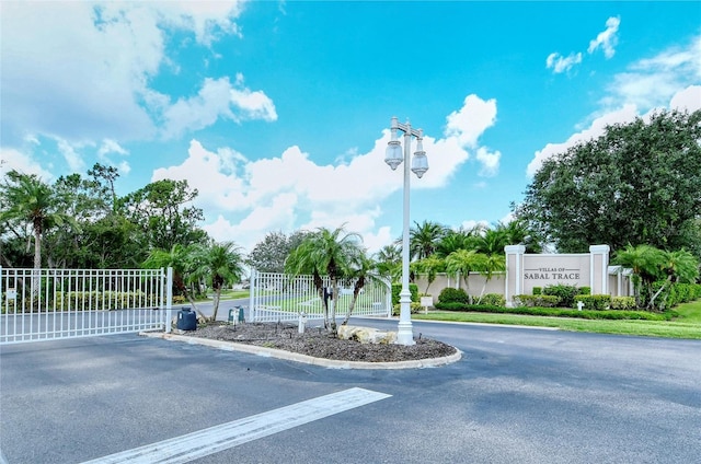 view of road with a gated entry and curbs