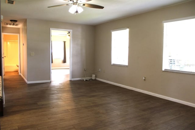 empty room featuring dark wood-type flooring and plenty of natural light