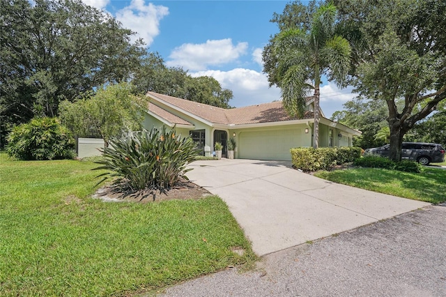 ranch-style home with a garage, a tile roof, driveway, stucco siding, and a front lawn