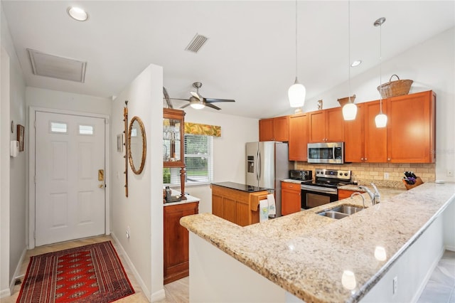 kitchen with decorative light fixtures, visible vents, appliances with stainless steel finishes, a sink, and a peninsula