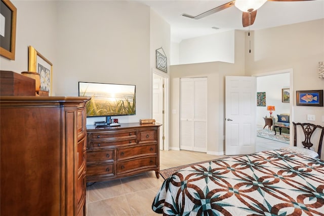 bedroom featuring baseboards, a closet, a towering ceiling, and a ceiling fan