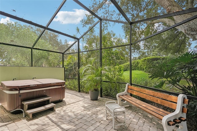 view of patio / terrace featuring a lanai and a hot tub