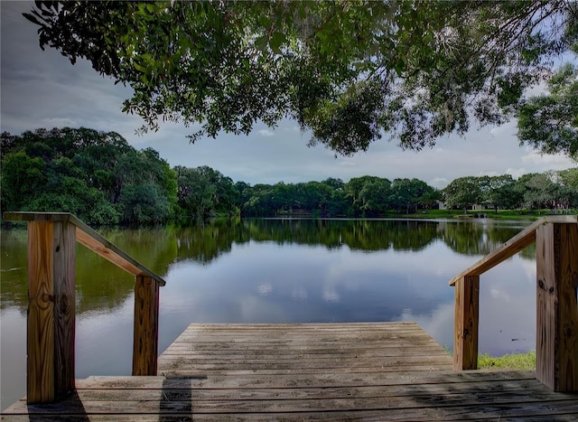 dock area featuring a water view and a wooded view