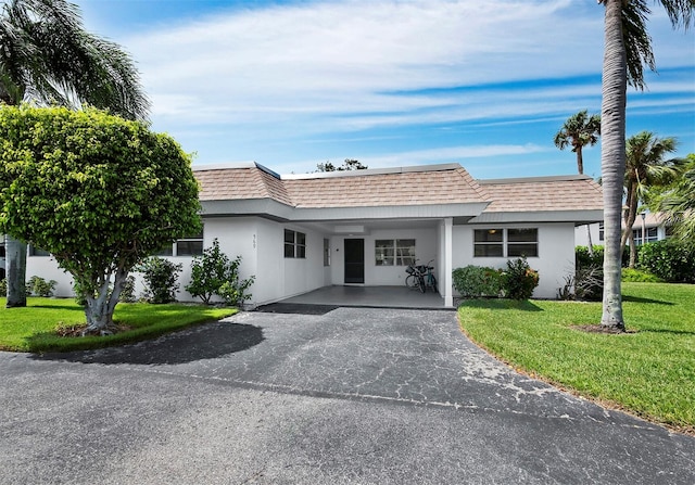 single story home featuring a front yard and a carport