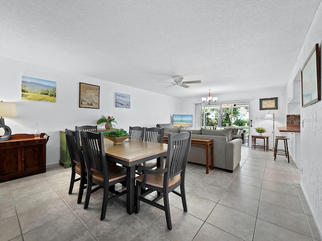 dining room featuring ceiling fan with notable chandelier, light tile patterned floors, and a textured ceiling