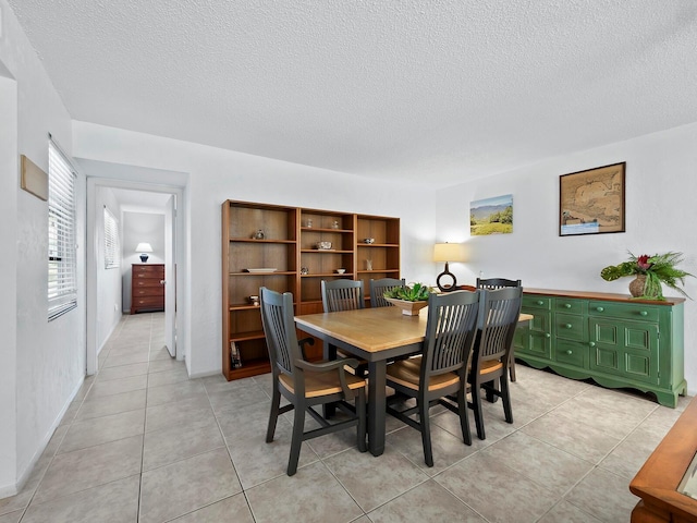 dining area featuring a textured ceiling and light tile patterned flooring