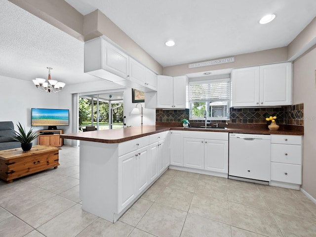 kitchen with dishwasher, a healthy amount of sunlight, sink, and kitchen peninsula