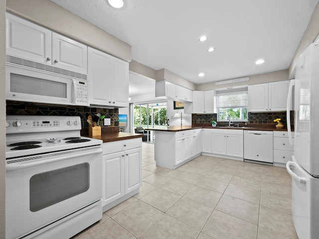 kitchen featuring white cabinets, white appliances, tasteful backsplash, and sink