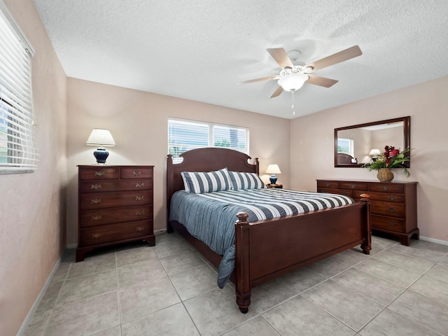 tiled bedroom featuring ceiling fan and a textured ceiling