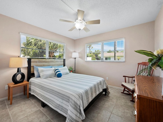 tiled bedroom featuring a textured ceiling and ceiling fan