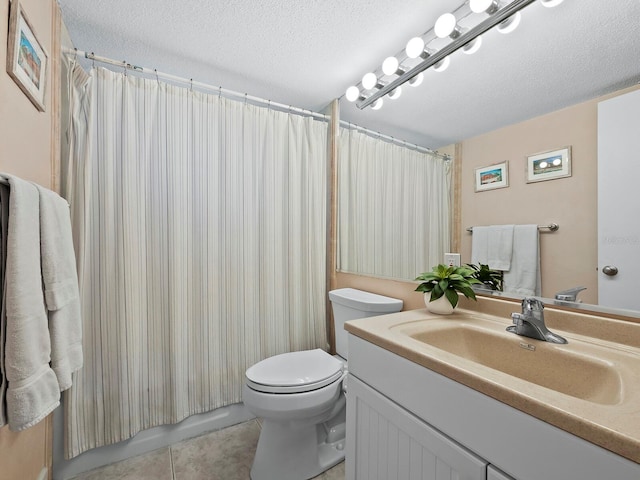 bathroom featuring vanity, toilet, tile patterned floors, and a textured ceiling