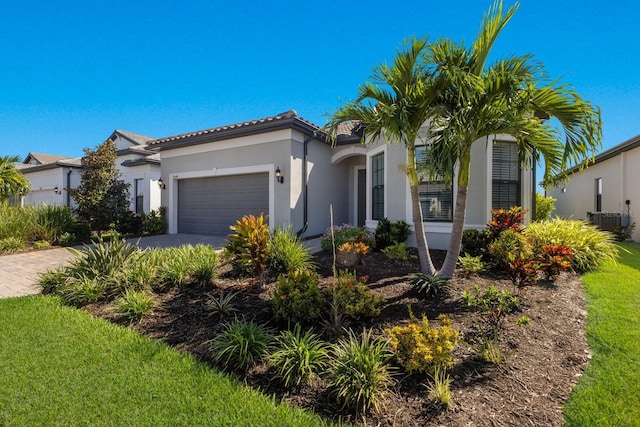 mediterranean / spanish house featuring central AC unit and a garage