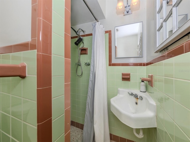 bathroom with sink, walk in shower, and tile walls