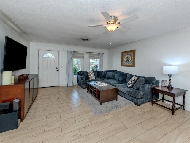 living room featuring a textured ceiling and ceiling fan