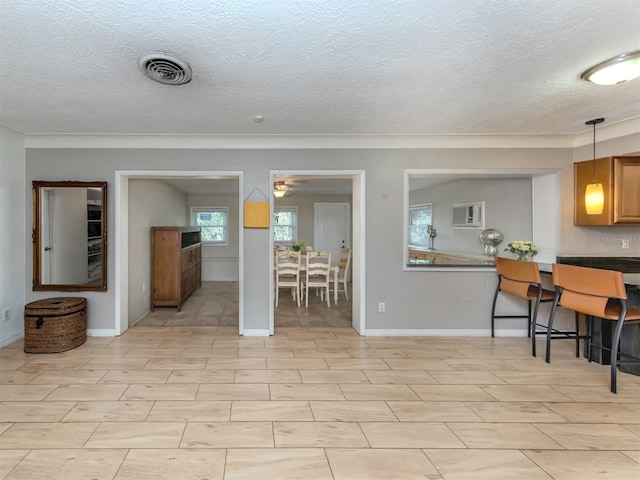 interior space with a textured ceiling and decorative light fixtures