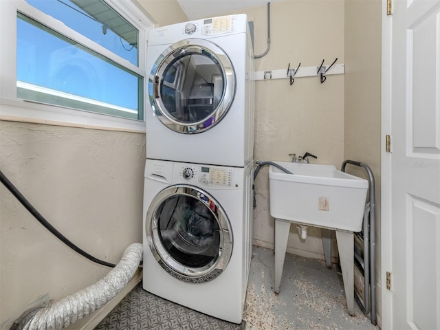 clothes washing area featuring stacked washer and clothes dryer