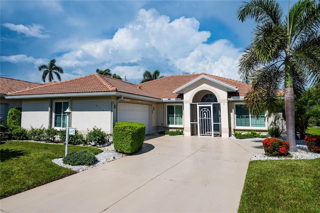 mediterranean / spanish home with an attached garage, concrete driveway, a tiled roof, stucco siding, and a front lawn