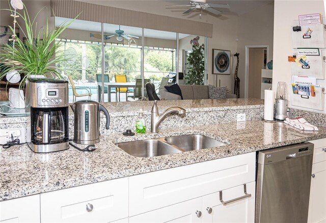 kitchen featuring dishwasher, a sink, and white cabinetry