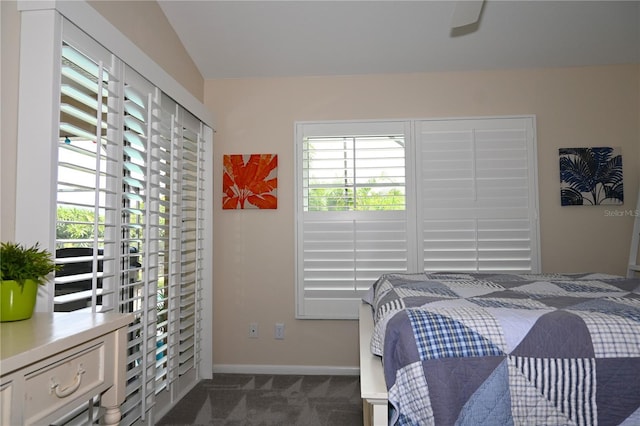 bedroom with baseboards and dark colored carpet