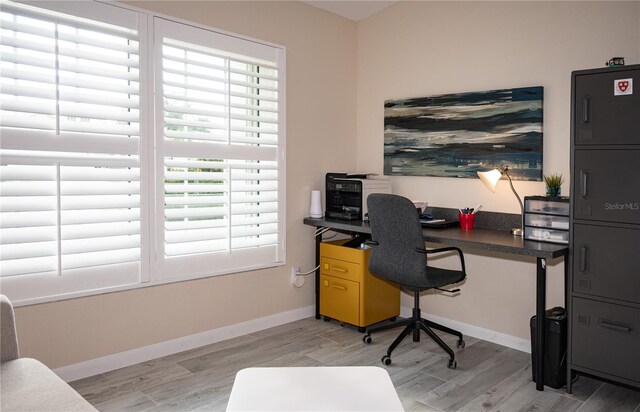 home office with light hardwood / wood-style flooring