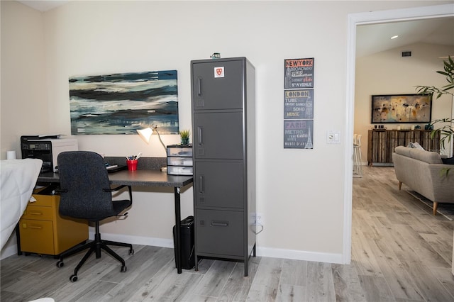 office featuring lofted ceiling and light hardwood / wood-style floors