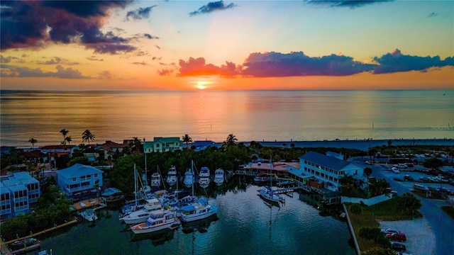 aerial view at dusk featuring a water view