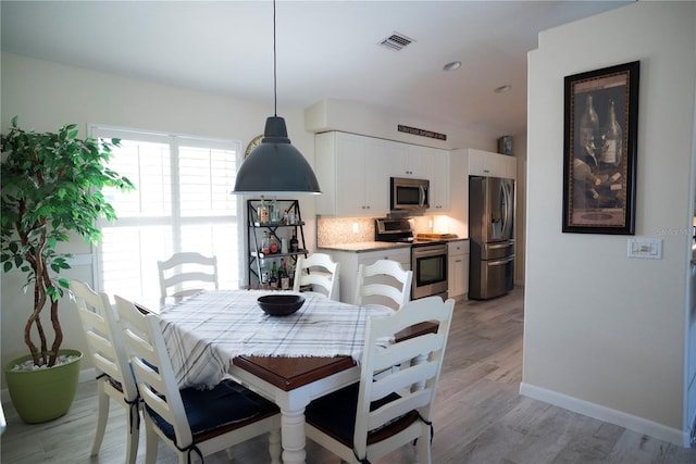 dining space with light hardwood / wood-style flooring