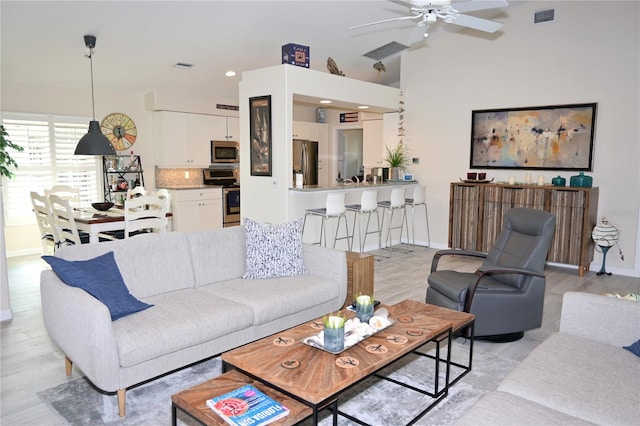 living room featuring ceiling fan and light hardwood / wood-style flooring