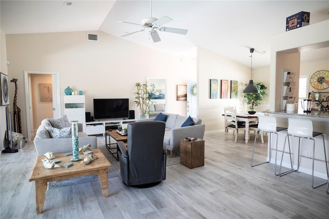 living room featuring vaulted ceiling, ceiling fan, and light wood-type flooring