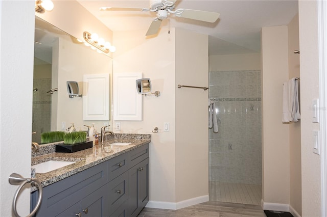 bathroom with ceiling fan, vanity, and a tile shower