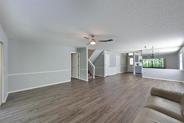 unfurnished living room with ceiling fan with notable chandelier, a textured ceiling, and dark hardwood / wood-style floors