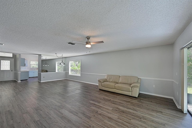 unfurnished living room featuring ceiling fan, a textured ceiling, and dark hardwood / wood-style floors