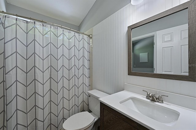 bathroom featuring vanity, lofted ceiling, and toilet