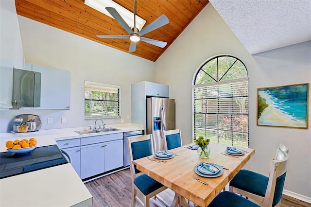 interior space featuring ceiling fan, high vaulted ceiling, hardwood / wood-style flooring, a textured ceiling, and sink