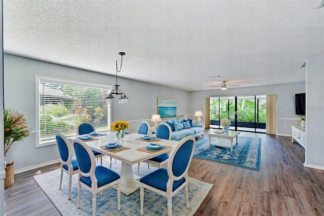 dining area featuring a textured ceiling, plenty of natural light, and hardwood / wood-style floors