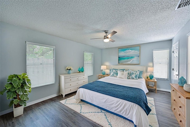 bedroom featuring ceiling fan, dark wood-type flooring, and a textured ceiling