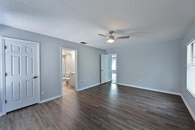 unfurnished bedroom featuring ceiling fan, hardwood / wood-style flooring, a textured ceiling, and ensuite bath