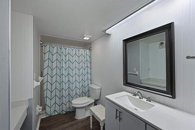 bathroom with toilet, vanity, and wood-type flooring