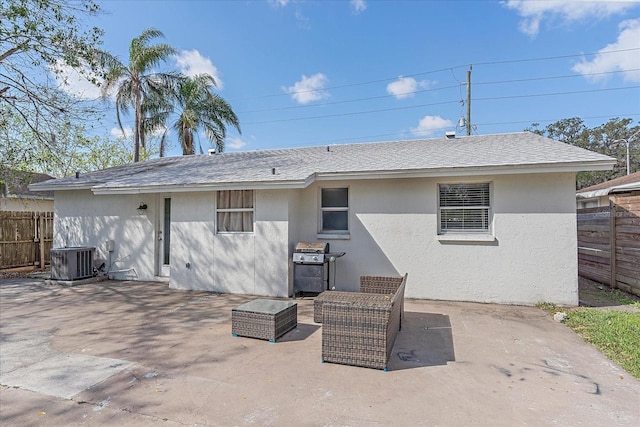 rear view of property with central air condition unit and a patio area